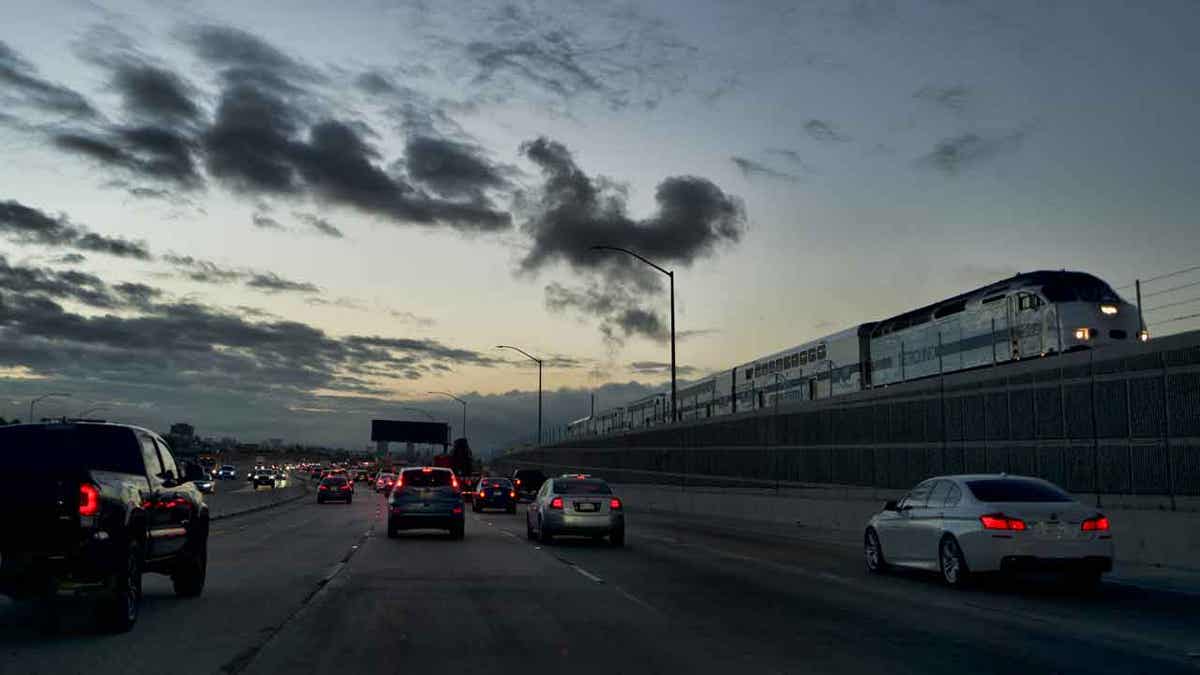 A Metrolink train passes early morning commuters