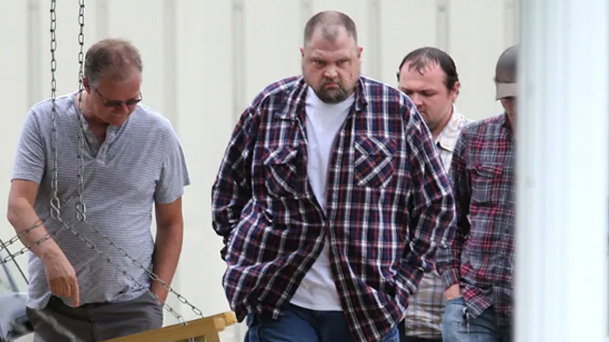 Members of the Wagner family wearing plaid shirts and jeans attending the funeral of one of the Rhoden family members they allegedly murdered