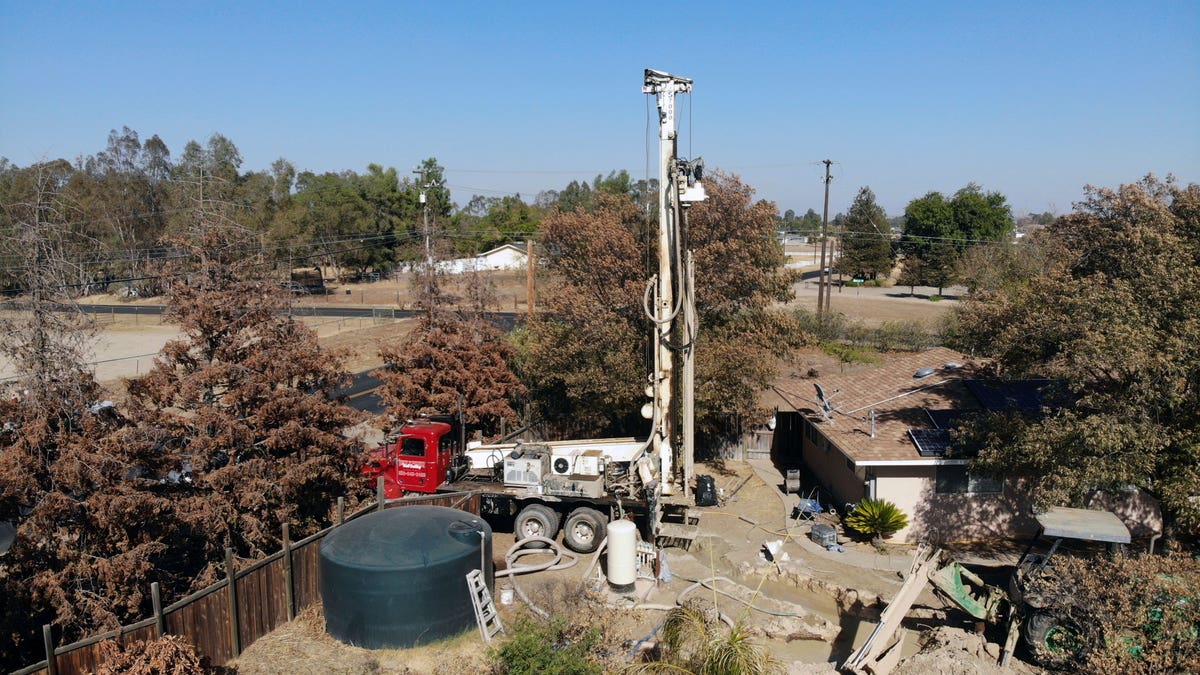 Well-drilling rig installing a well