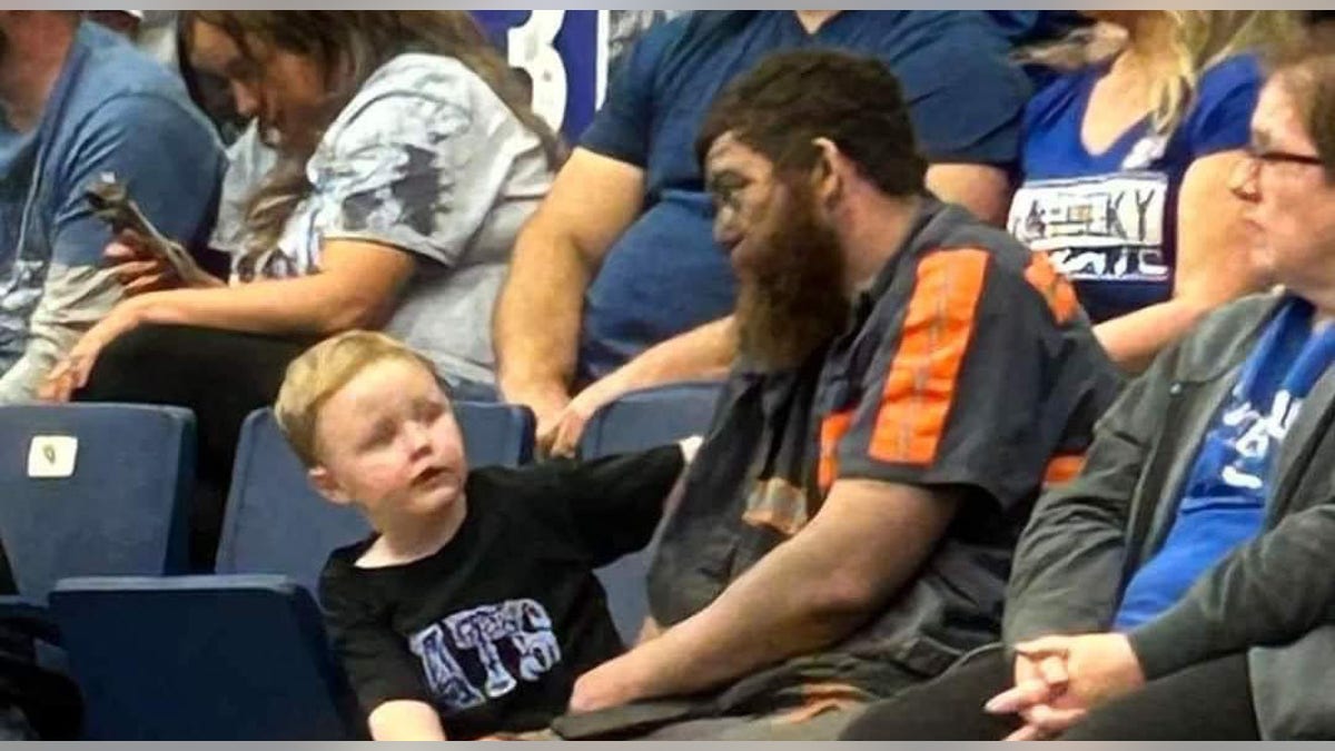 Coal miner Michael McGuire sits with son at Kentucky game