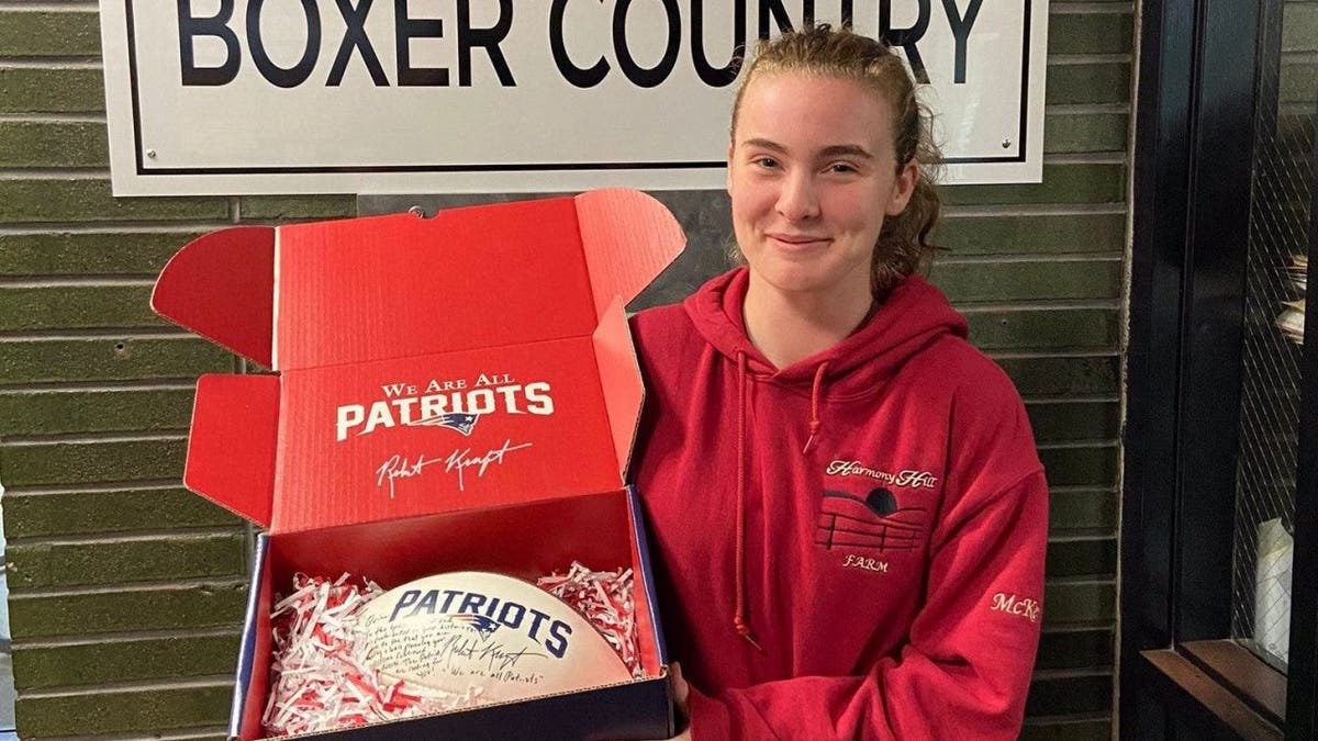 Girl holding a signed New England Patriots football