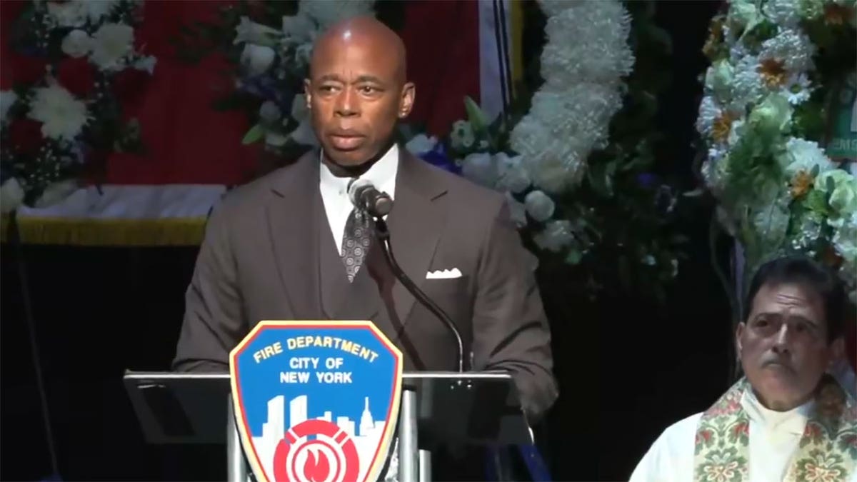 NYC Mayor Eric Adams at podium during slain paramedic's funeral