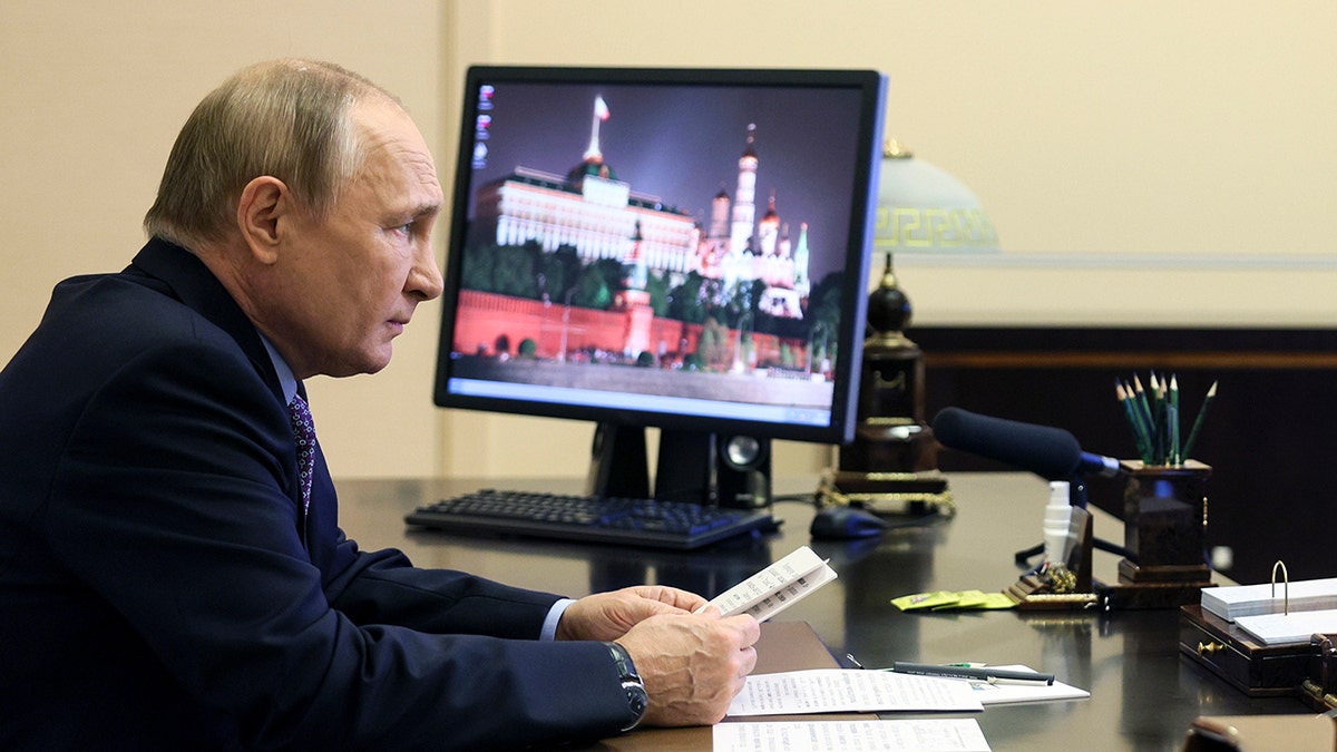 Putin sitting in front of computer