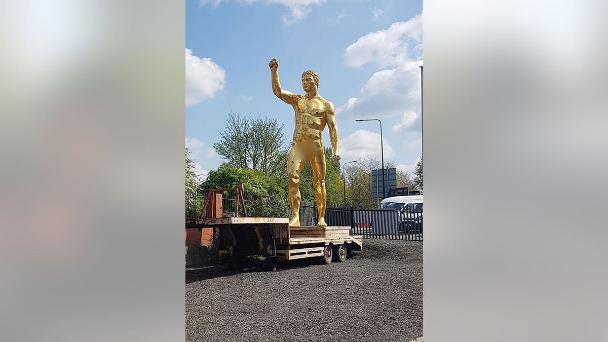 Golden statue ready to be towed away while atop a wooden platform