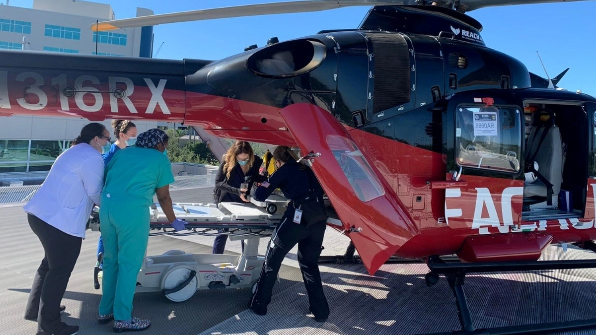 Medical personnel preparing to unload patient from helicopter