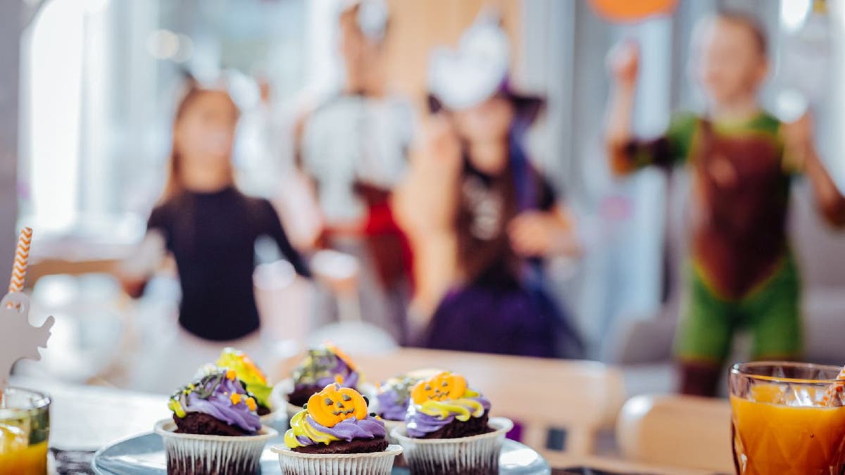 School children attend a Halloween party with cupcakes and juice