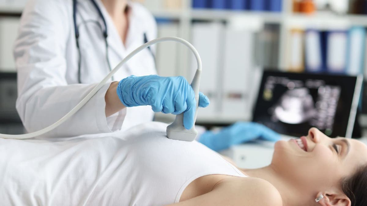 doctor conducts breast ultrasound on a patient