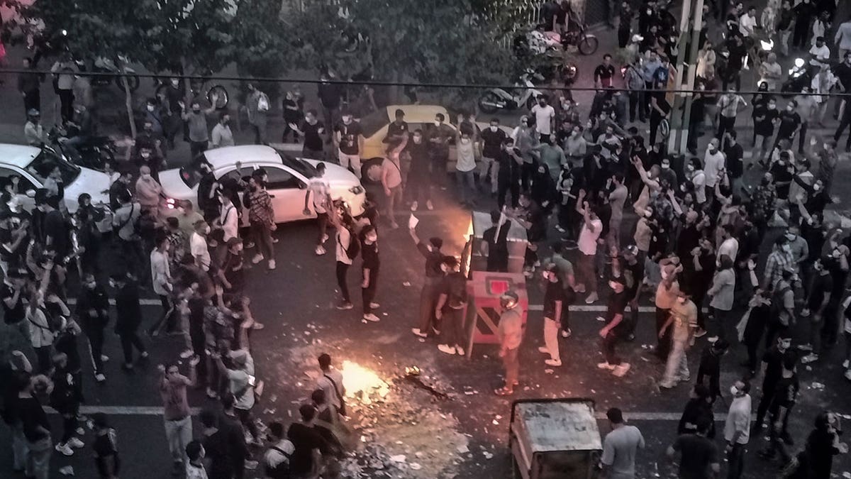 Protestors light fire in middle of the street during Mahsa Amini protests