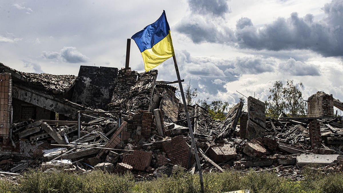 The Ukrainian flag waving over heavily damaged Lyman