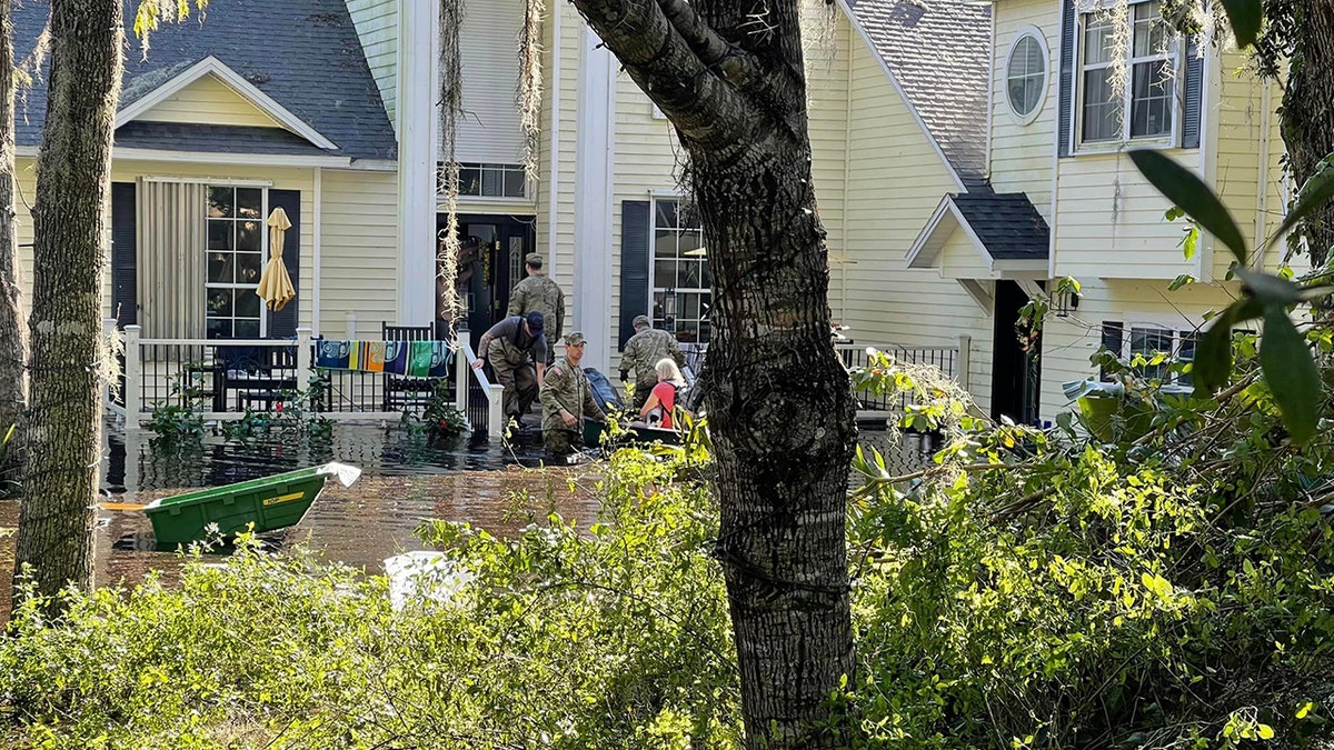 rescuers outside flooded home