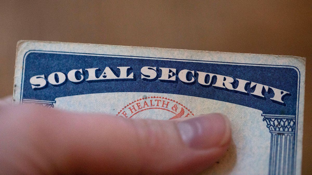 A person covers their Social Security number with their thumb