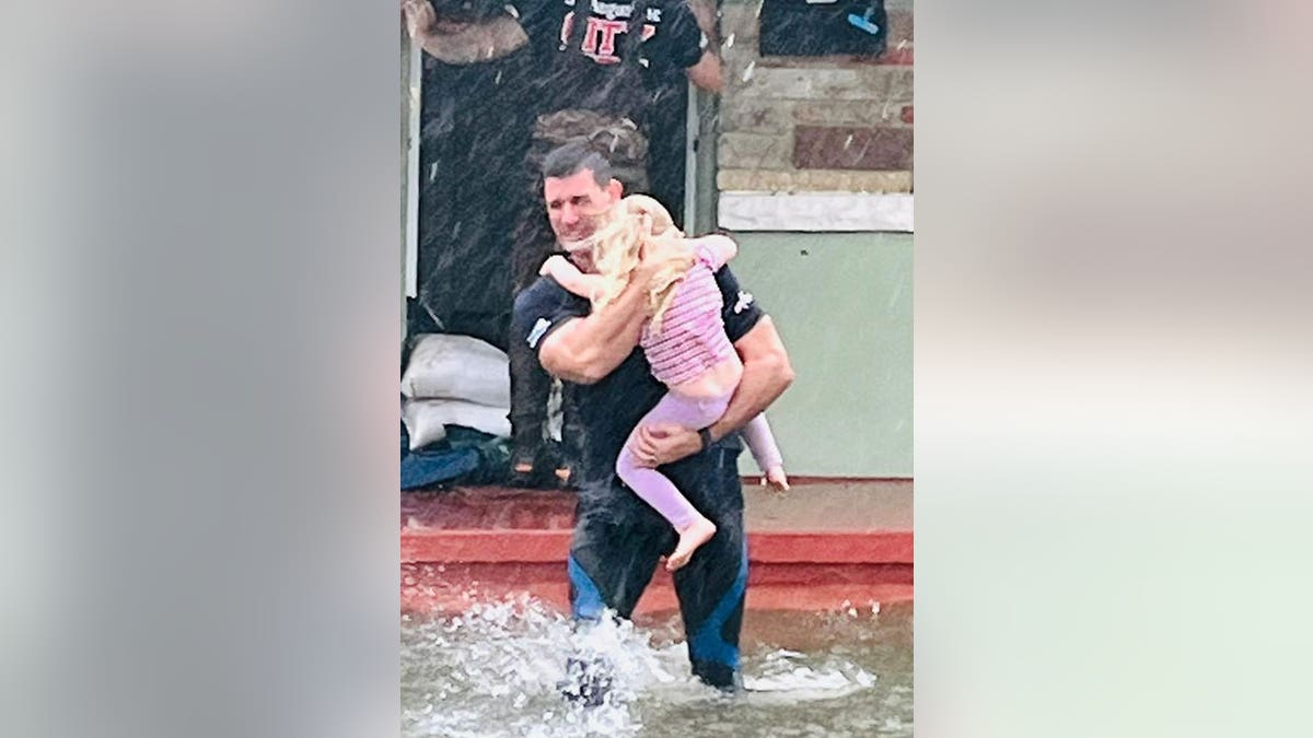 Firefighter carries little girl through flooding in St. Augustine during Hurricane Ian