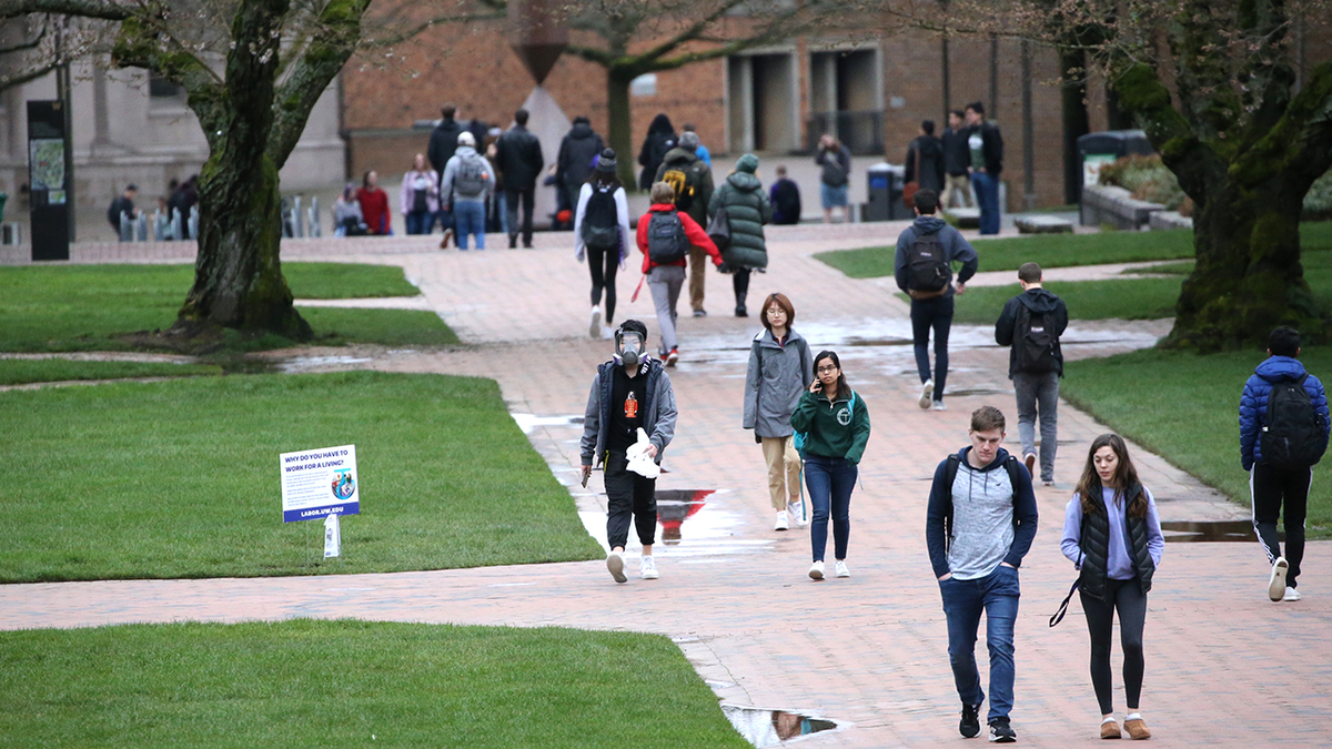 Students seen walking on sidewalk of campus at University of Washington in Seattle 