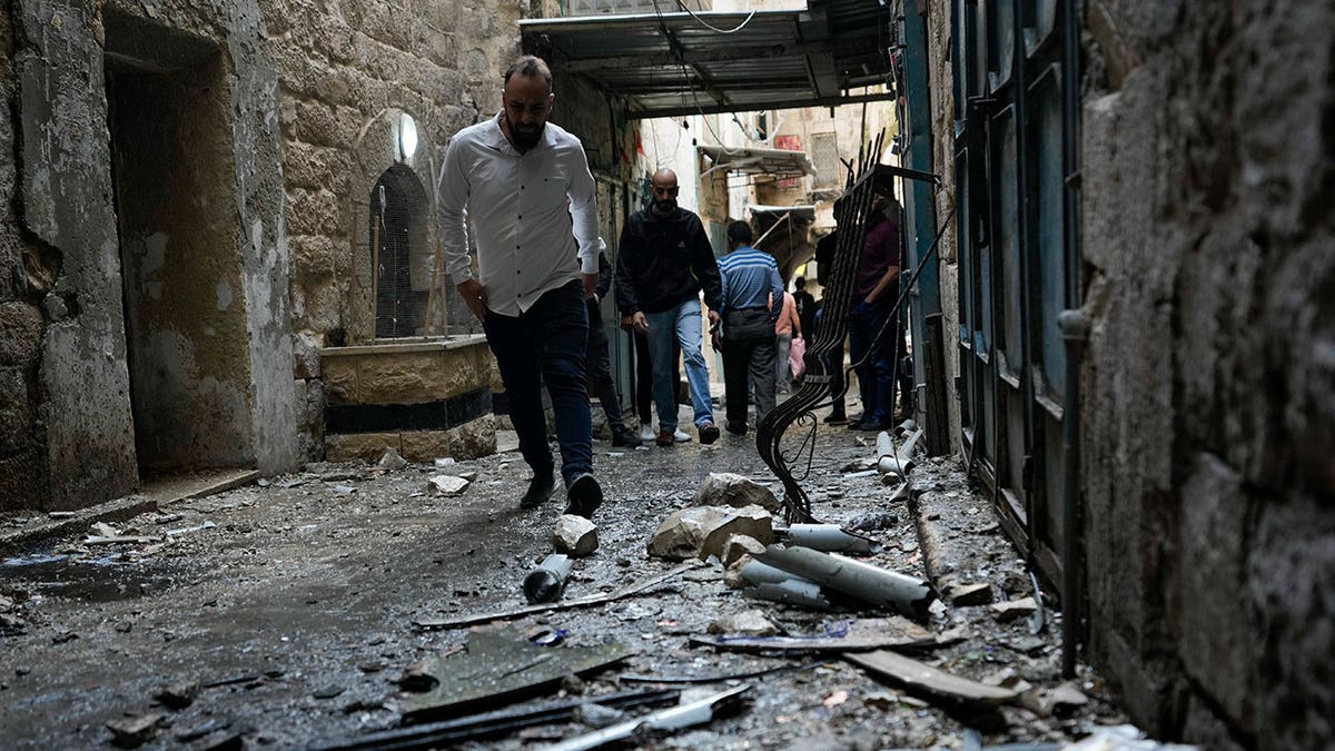 Man walks over rubble following attacks in West Bank