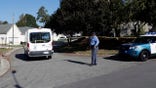 A Raleigh police officer allows a person to return home on Sahalee Way, which remains closed except for residents following a shooting in Raleigh, N.C., seen on Friday, Oct. 14, 2022. Several people were shot and killed by a gunman in the neighborhood Thursday night, Oct. 13, 2022.