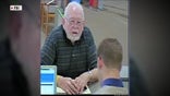 Donald Griffith, who had $750,000 stolen from him in a romance scam, deposits money at a bank teller.
