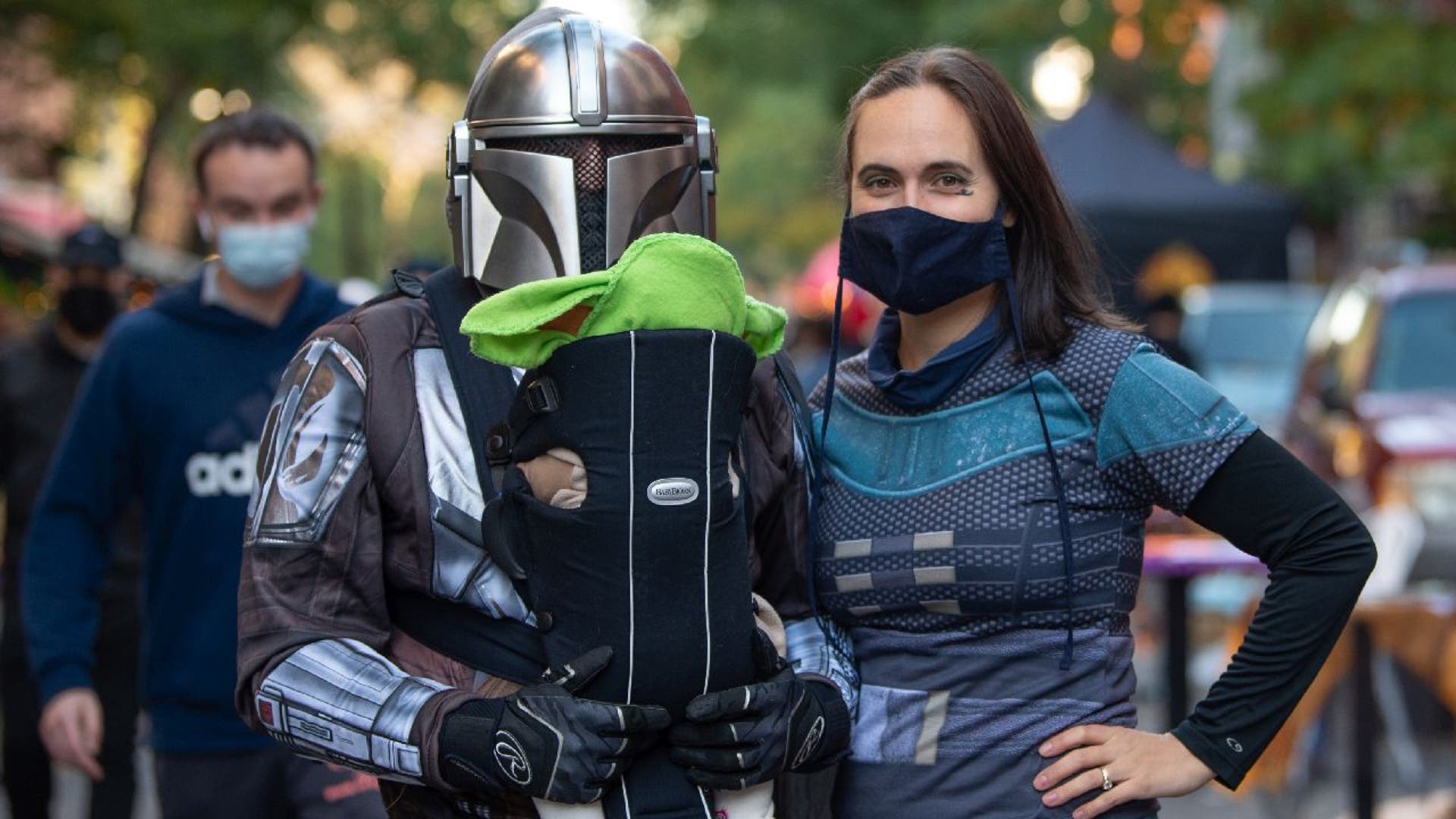 A man, woman and baby dressed in costumes from "The Mandalorian."