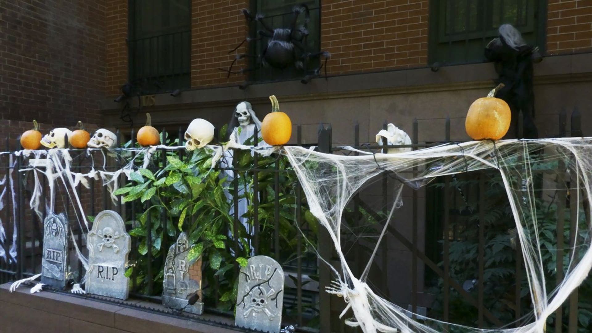 Building stoop decorated with spider webs, tombstones and pumpkins