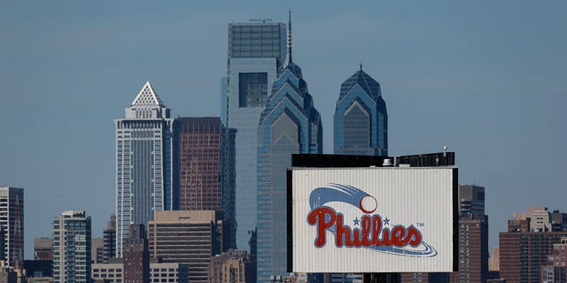 A Philadelphia Phillies sign in the foreground of the Philadelphia skyline Aug. 25, 2013, in Philadelphia.