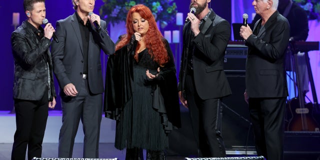 Wes Hampton, Reggie Smith, and Adam Crabb of the Gaither Vocal Band, along with Wynonna Judd and Larry Strickland gave the opening performance of Loretta Lynn's tribute, singing "How Great Thou Art."