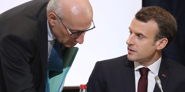 French President Emmanuel Macron, right, speaks with presidential diplomatic advisor Philippe Etienne during the Cedar Conference for international donors and investors to support Lebanon's economy, in Paris April 6, 2018.