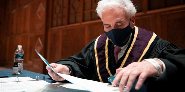 Justice Max Baer verifies the certificates during the 59th Pennsylvania Electoral College meeting, where the commonwealth’s 20 electors unanimously voted for Joe Biden for president and Kamala Harris for vice president, in Harrisburg, Pennsylvania, Dec. 14, 2020.