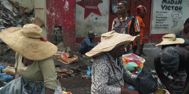 Women offer produce at a market while people stock up on food amid shortages of water, cooking gas and other items after days of protest forced them to shelter at home, in Port-au-Prince, Haiti Sept. 17, 2022.