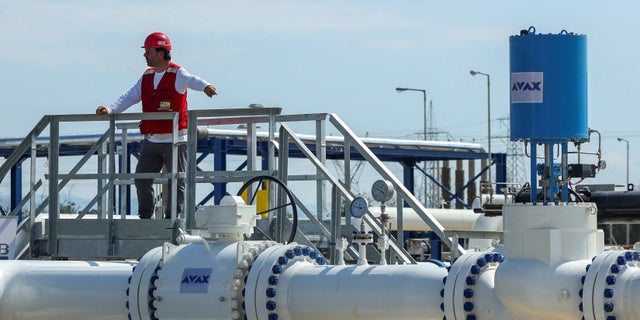 A member of the staff stands over part of the Interconnector Greece-Bulgaria (IGB) gas pipeline that will carry gas from Komotini to Stara Zagora in Bulgaria, in Komotini, Greece, July 8, 2022.
