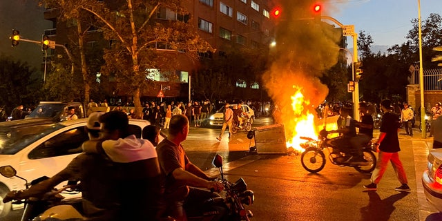 A police motorcycle burns during a protest over the death of Mahsa Amini, a woman who died after being arrested by the Islamic republic's "morality police", in Tehran, Iran September 19, 2022. 