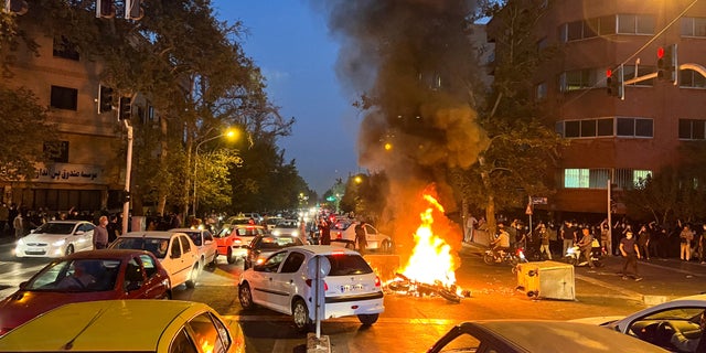 A police motorcycle burns during a September 19 2022 protest in Tehran, Iran, over the death of Mahsa Amini, a young Iranian woman who died after being arrested by the nation "moral police." (West Asian News Agency via Reuters)