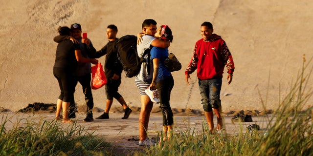 Un couple de migrants vénézuéliens demandant l'asile s'embrasse après avoir traversé le fleuve Rio Bravo pour se rendre aux agents de la patrouille frontalière américaine pour demander l'asile à El Paso, Texas, États-Unis, vu de Ciudad Juarez, Mexique le 6 octobre 2022. REUTERS/Jose Luis Gonzalez