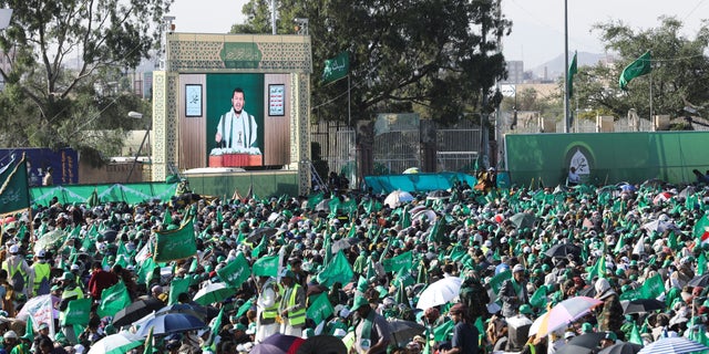 Leader of the Houthi movement Abdul-Malik Badruddin al-Houthi addresses a rally marking the birthday of the Prophet Muhammad through a TV screen in Sanaa, Yemen, October 8, 2022. 