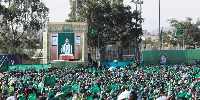 Leader of the Houthi movement Abdul-Malik Badruddin al-Houthi addresses a rally marking the birthday of the Prophet Muhammad through a TV screen in Sanaa, Yemen, October 8, 2022.