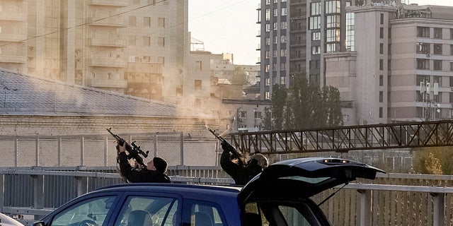 Police officers fire on a drone during a strike by a Russian drone, believed by local authorities to be an Iranian-made Shahed-136 unmanned aerial vehicle, amid Russia's attack on Ukraine, in Kyiv, Ukraine October 10.  17, 2022.