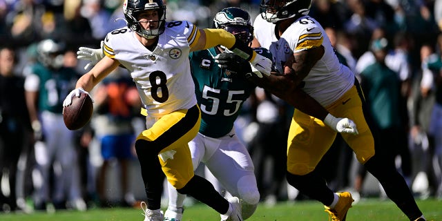 Pittsburgh Steelers quarterback Kenny Pickett, #8, evades a tackle by Philadelphia Eagles defensive end Brandon Graham, #55, during the first half of an NFL football game between the Pittsburgh Steelers and Philadelphia Eagles, Sunday, Oct. 30, 2022, in Philadelphia.