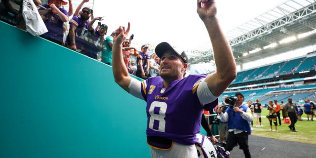 Kirk Cousins #8 of the Minnesota Vikings celebrates with fans in the tunnel after an NFL football game against the Miami Dolphins at Hard Rock Stadium on October 16, 2022 in Miami Gardens, Florida.