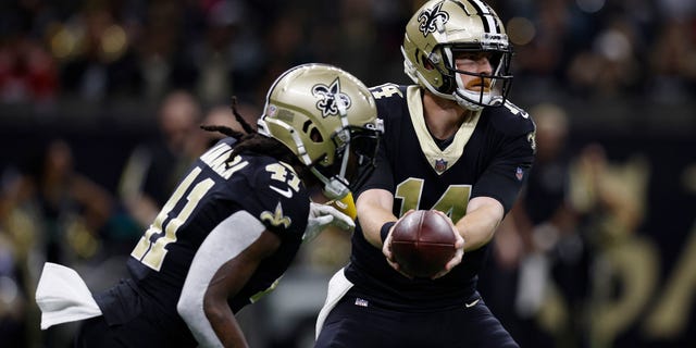 Andy Dalton (14) of the New Orleans Saints passes the ball to Alvin Kamara in the first quarter against the Las Vegas Raiders on October 30, 2022 in New Orleans.