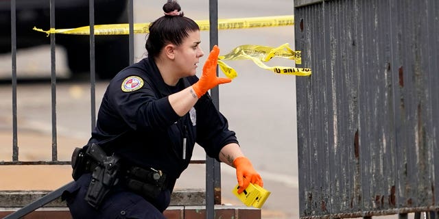 A member of the St. Louis Police Department investigates the scene of a shooting at Central Visual and Performing Arts High School Monday, Oct. 24, 2022, in St. Louis.