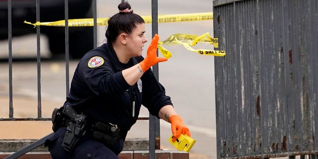 A member of the St. Louis Police Department investigates the scene of a shooting at Central Visual and Performing Arts High School Monday, Oct. 24, 2022, in St. Louis.