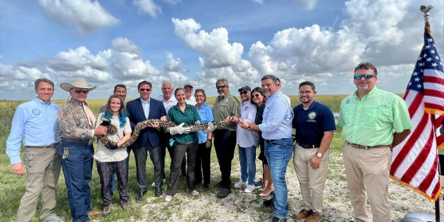 Florida Fish & Wildlife Conservation officials, Florida Gov. Ron DeSantis and others hold a Burmese python at the 2022 Florida Python Challenge.