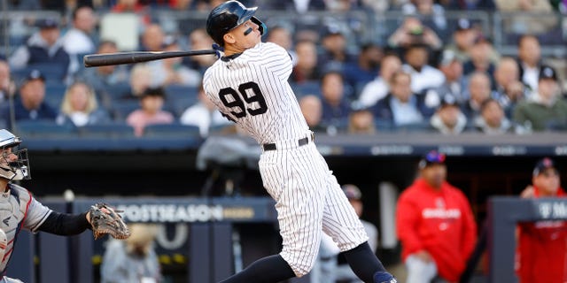 Aaron Judge #99 of the New York Yankees hits a home run against the Cleveland Guardians during the second inning in game five of the American League Division Series at Yankee Stadium on October 18, 2022 in New York, New York.
