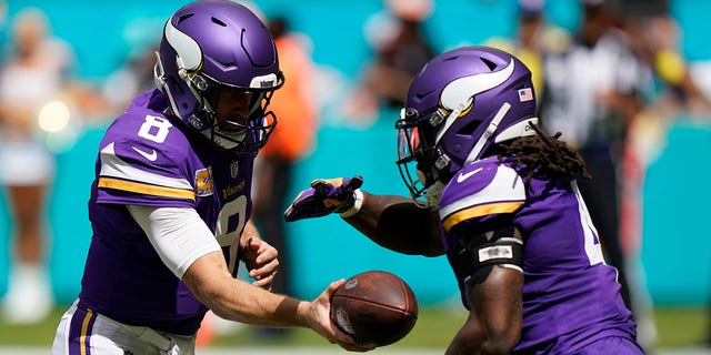 Minnesota Vikings quarterback Kirk Cousins, #8, hands off to Minnesota Vikings running back Dalvin Cook, #4, during the first half of an NFL football game, Sunday, Oct. 16, 2022, in Miami Gardens, Florida.