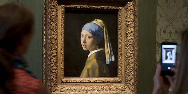 Visitors take pictures of Johannes Vermeer's Girl with a Pearl Earring (approx. 1665) during a preview for the press of the renovated Mauritshuis in The Hague, Netherlands, June 20, 2014.