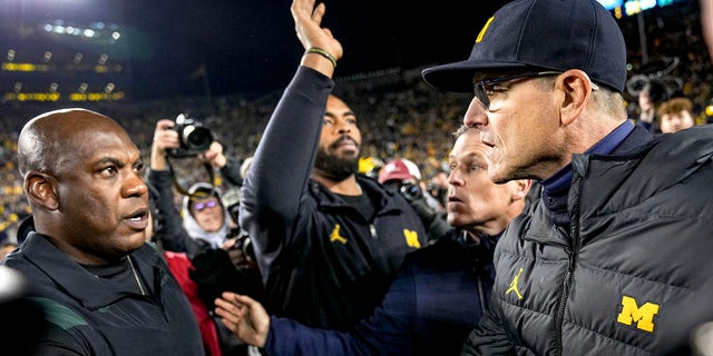 Hoofdcoach Jim Harbaugh van de Wolverines schudt hoofdcoach Mel Tucker van de Spartans de hand in het Michigan Stadium op 29 oktober 2022 in Ann Arbor.