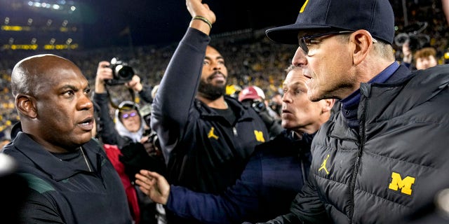 Wolverines head coach Jim Harbaugh shakes hands with Spartans head coach Mel Tucker at Michigan Stadium in Ann Arbor on October 29, 2022.