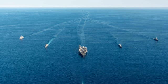 FILE - In this photo provided by the South Korea Defense Ministry, the USS Ronald Reagan aircraft carrier, center, participates in a joint anti-submarine drill among South Korea, the United States and Japan in waters off South Korea's eastern coast in South Korea on Sept. 30, 2022.