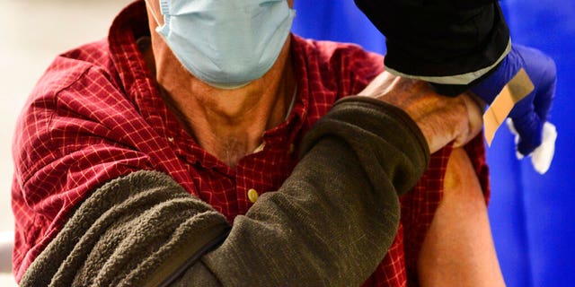 FILE - A man receives a flu shot in Brattleboro, Virginia, Tuesday, October 26, 2021. Doctors have a message for vaccine-weary Americans. Older people are encouraged to acquire special special strength types. 