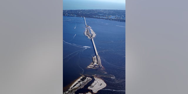 Damage from Hurricane Ian is seen on the causeway leading to Sanibel Island, background, from Fort Myers, Fla., Friday, Sept. 30, 2022. 