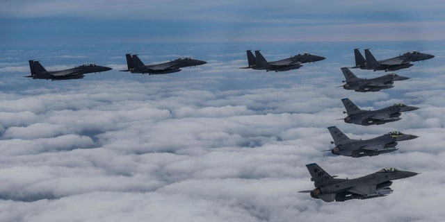 La ĉasaviadiloj F15K de la sudkorea aerarmeo kaj la ĉasaviadiloj F-16 de la usona aerarmeo flugas en formado dum komuna ekzercado en nekonita loko en Sud-Koreio, mardon, la 4-an de oktobro 2022.