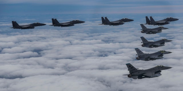 In this photo provided by South Korea Defense Ministry, South Korean Air Force's F15K fighter jets and U.S. Air Force's F-16 fighter jets, fly in formation during a joint drill in an undisclosed location in South Korea, Tuesday, Oct. 4, 2022. (South Korea Defense Ministry via AP)